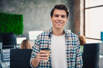 Casual young professional enjoying a coffee break in a modern office space, embodying collaboration