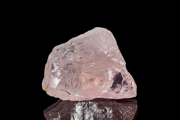 Natural rough rose quartz gemstone on dark background (selective focus)