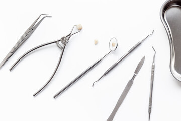 Dental crowns with steel instruments for dental prosthetics, top view. Dentist desk, white background