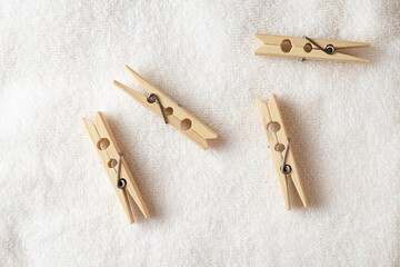 Wooden clothespins on a soft white surface, ready for daily use
