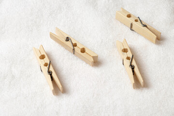 Wooden clothespins resting on a soft white surface in a cozy setting