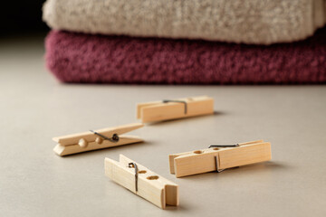 Wooden clothespins resting on a soft surface with towels in the background