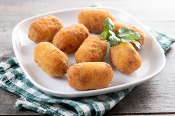 Fried cod croquettes on wooden table