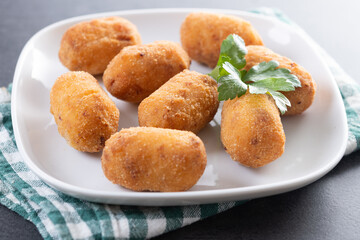 Fried cod croquettes on black background