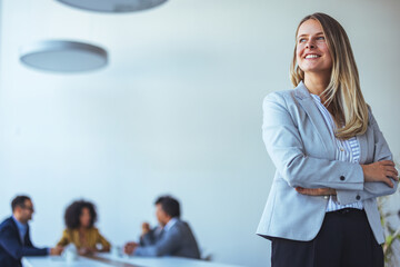 Confident Businesswoman Smiling in Modern Office Setting with Team Collaboration