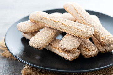 Italian biscuits ladyfingers savoiardi on wooden table
