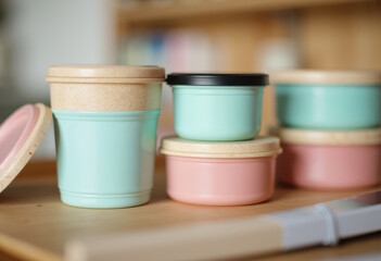 Colorful storage containers in pastel shades arranged on a wooden surface