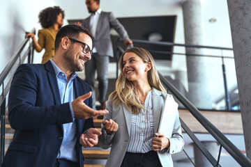 Colleagues Engaging in Conversation on Office Stairs During a Productive Workday