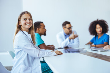 Fototapeta premium Medical Team Meeting with Smiling Doctor in White Coat Focused on Collaboration