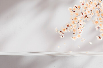 Easter background with apple blossom branch and white table. Spring flower backdrop for beauty, cosmetic and luxury brand display mockup. Natural minimal aesthetic template.