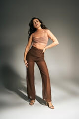 Fototapeta premium Elegant summer styling featuring a young woman in modern attire exuding confidence and charm