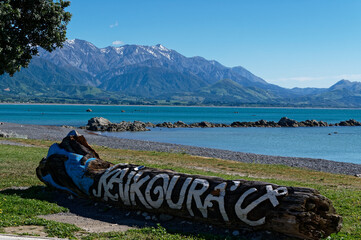 A place name, Kaikoura, painted on a log at the waterfront