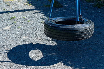 A fun tyre swing hangs waiting for someone to use it