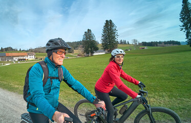 nice senior couple cycling in spring and having fun