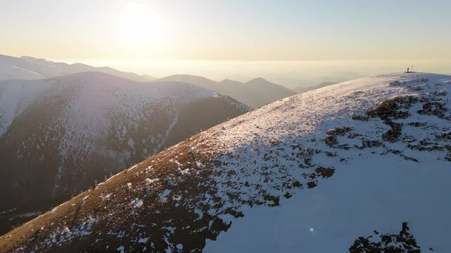 Aerial orbit of mountain scenery before sunset between winter and spring