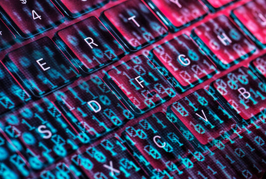 Close-up of a glowing keyboard with digital code representing cybersecurity and cyber crime concepts