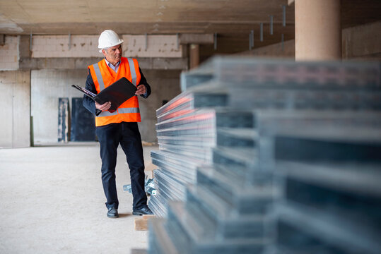 Engineer inspecting a shell construction site with a clipboard