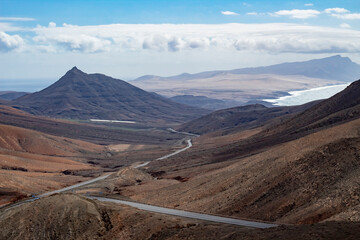 Serpentine coastal road cutting through volcanic valleys on Fuerteventura.