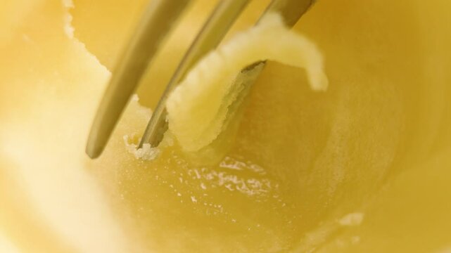 A fork scrapes fresh ghee clarified butter. Healthy homemade fatty ingredient. Macro shot