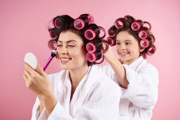 Pretty mother and daughter in hair curlers