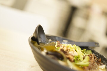 Detail of an oriental soup bowl with different textures and foods