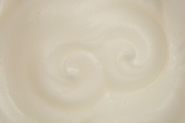 A top-down, close-up shot of whipped egg whites, showcasing their airy texture and subtle sheen