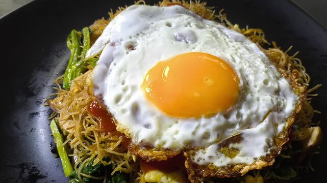 Fried egg on fried vermicelli, in door  Chiangmai  Thailand.