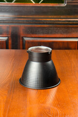 Black metal studio light attachment on wooden table