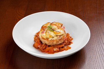 Beautiful elegant dish of vegetables and tomato sauce on a white plate