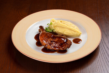 Baked duck leg with berry sauce and mashed potato garnish