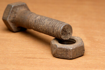 Rusty bolt and nut resting on a wooden table