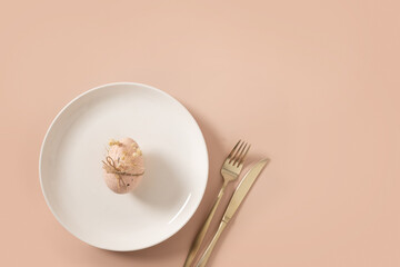 Easter table setting with white plate, pink egg decorated white gypsophila on pink background....