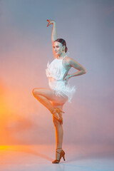 Passionate female dancer in a white fringe dress performing a dynamic Latin dance, surrounded by...