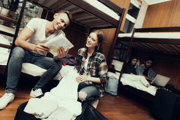 Man looking on map and Girl unpacks bag.