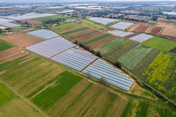 Farm greenhouses in a field, aerial view of a rural landscape