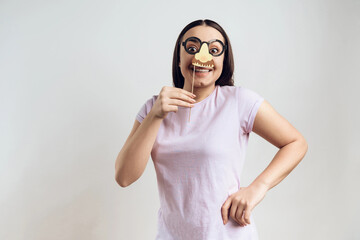 Young girl posing with fake nose.