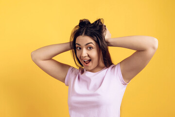 Fototapeta premium Young joyous girl ruffles long hair on head.