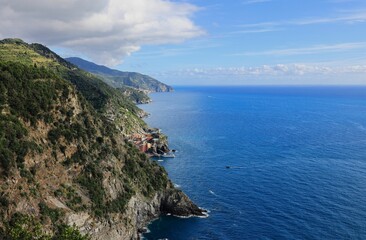 Cinque Terre coastline with lush cliffs and azure sea.