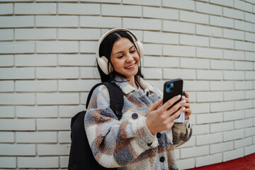 Portrait of a teenage girl smile and use cellphone to send text messages sms and take self...