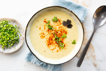 Jerusalem artichoke or cauliflower and potato puree soup in a ceramic bowl.