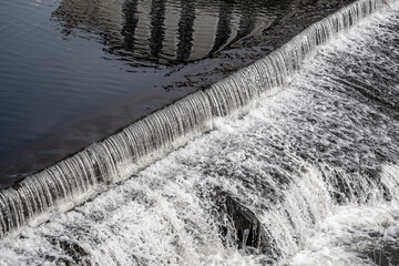 A small threshold on a dam with water.