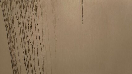 Abstract close-up of water stains and markings on a textured surface with varied hues of beige and brown tones