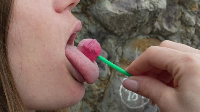 Lollipop Tongue Woman outdoors Pink candy lick during daylight over 18 content rock art background