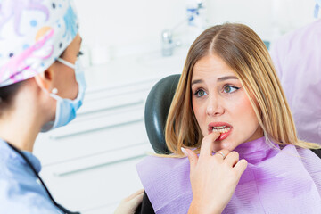 Worried patient touching teeth at the dental clinic