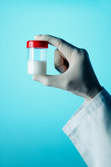 man holds a sterile container with some semen