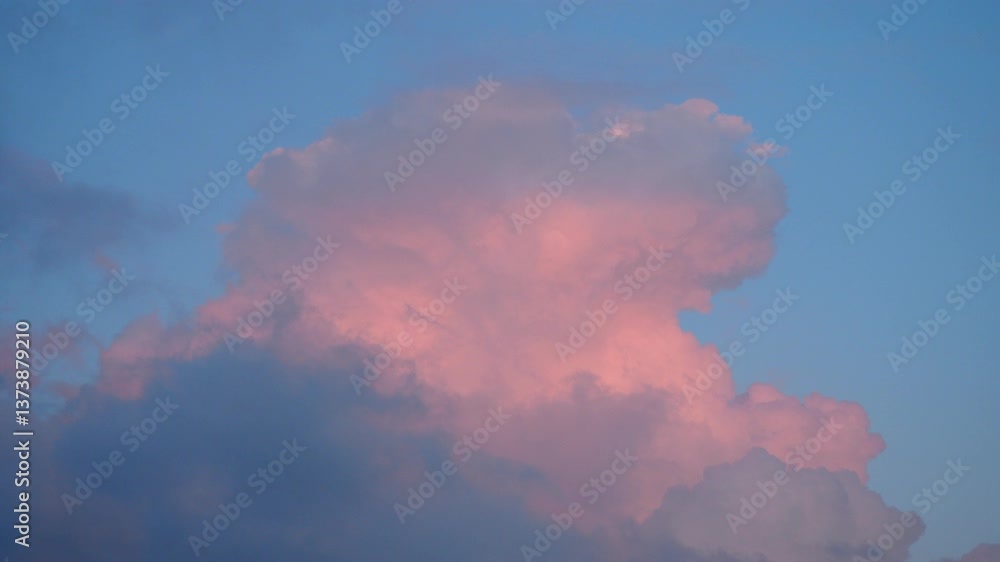 Poster A stunning pink evening cloud emerges gracefully in the twilight sky, casting a serene glow. This captivating display captures the essence of a peaceful evening, inviting reflection and wonder