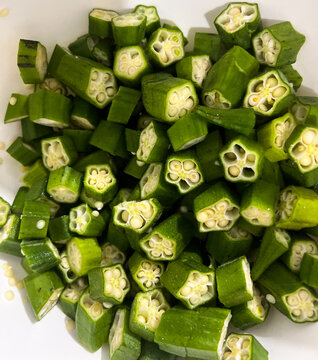 Fresh okra, Abelmoschus esculentus, sliced on a cutting board. Hibiscus esculentus, popular food in many cuisines, ideal for vegetarian and vegan cooking, healthy food concept