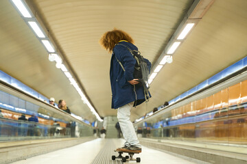 Young adult skateboarding in urban subway tunnel
