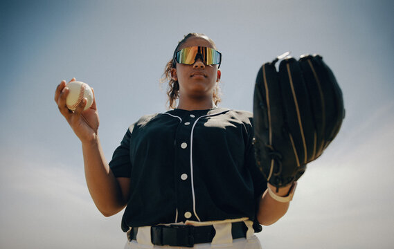 Confident baseball pitcher holding mitt and ball wearing sunglasses - Powered by Adobe