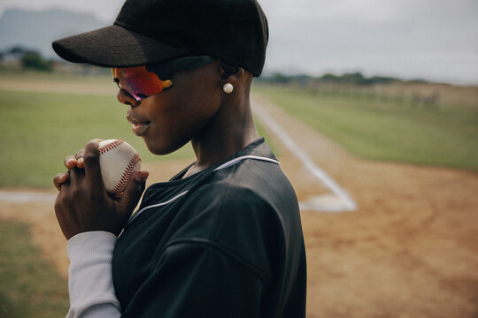 Focused baseball pitcher preparing to throw a fastball with the baseline in the background